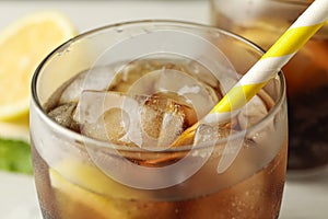 Glasses with cold cola and citrus on white cement background