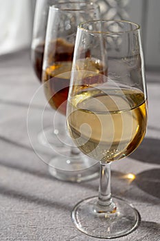 Glasses with cold dry fino and sweet cream sherry fortified wine in sunlights, andalusian style interior on background