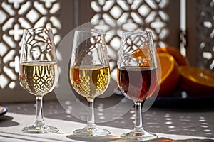 Glasses with cold dry fino and sweet cream sherry fortified wine in sunlights, andalusian style interior on background