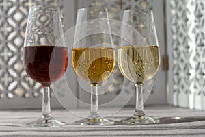 Glasses with cold dry fino and sweet cream sherry fortified wine in sunlights, andalusian style interior on background