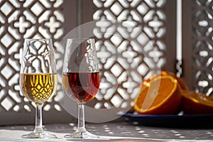 Glasses with cold dry fino and sweet cream sherry fortified wine in sunlights, andalusian style interior on background