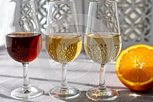 Glasses with cold dry fino and sweet cream sherry fortified wine in sunlights, andalusian style interior on background