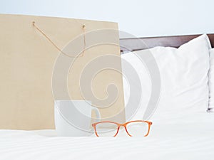 Glasses, cup and Paper bags gray on bed.