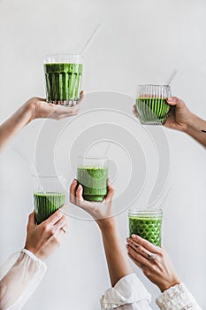 Glasses of detox healthy green smoothie in hands