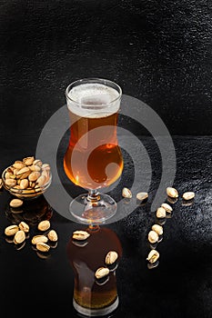 Glasses with different types of craft beer on a wooden bar. In glasses and bottles. Nuts and crackers on the table. On a