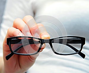 Glasses on display held by a shop assistant at an optician shop