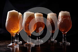 glasses of draught beer in a row, with foaming and carbonation visible