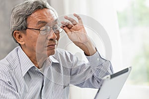 glasses elderly old man happy using looking at Tablet screen