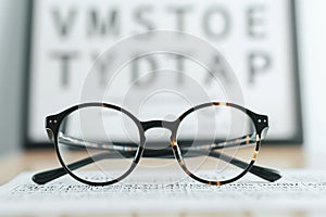 Glasses on eye test chart background