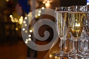 Glasses filled with champagne with soft background lights