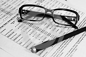 Glasses, financial documents and pencil