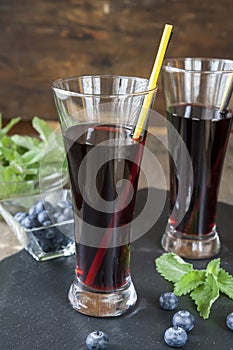 Glasses with fresh Black Currant juice. Bog blueberry and lemon balm