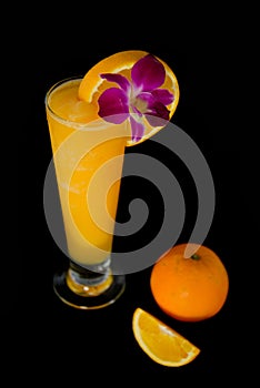 Glasses of fresh orange juice on black background