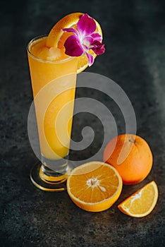 Glasses of fresh orange juice on dark background