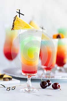 Glasses of frosty colourful mocktails surrounded by fruit for garnishment.