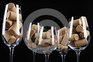 Glasses full of many wine corks on black background