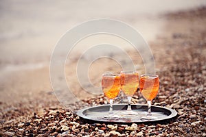 Glasses with a gazirvoannim refreshing drink on the beach among small pebbles.