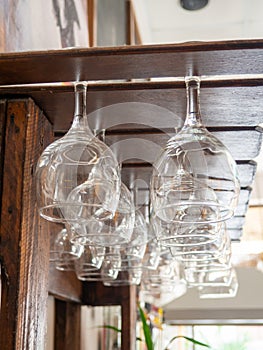 Glasses hang over the bar counter. The glasses are turned upside down. restaurant interior. Concept of drinking alcoholic