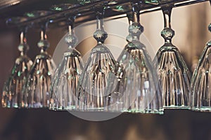 Glasses hanging on bar rack close up