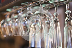 Glasses hanging on bar rack close up