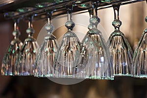 Glasses hanging on bar rack close up