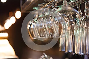 Glasses hanging on bar rack close up