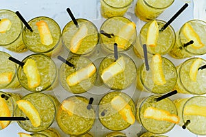Glasses with ice cubes and cocktails, pattern seen from above
