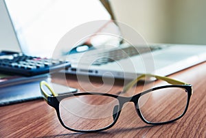 Glasses and laptop on the desk work place