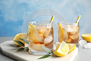 Glasses of lemonade with ice cubes and fruit on table