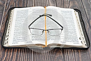 Glasses lie on the bible  close-up  background