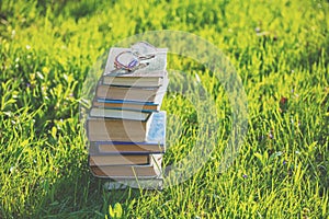 Glasses lie on a stack of books outdoors