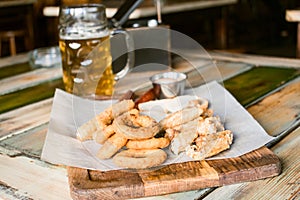 Glasses of light beer on pub background. Pint glass of golden beer with snacks