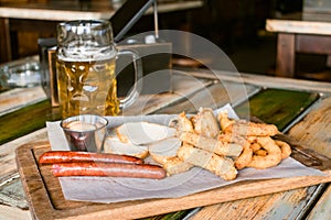 Glasses of light beer on pub background. Pint glass of golden beer with snacks