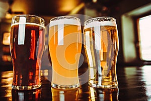 Glasses of light and dark beer on a pub background photo