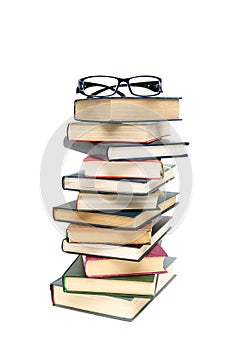 Glasses lying on a pile of books. white background - vertical ph