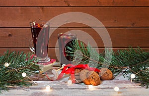 Glasses of mulled wine, chocolate chip cookies, pine branches and glowing christmas lights. Selective focus. Christmas concept