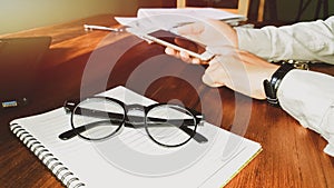 Glasses,Newsletter concept. Hand of businessman checking message box on mobile phone vintage tone filter