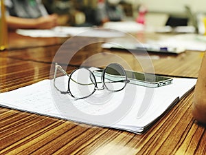 Glasses and notebook on the table in the office, business concept.