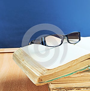 Glasses, old books and blackboard composition