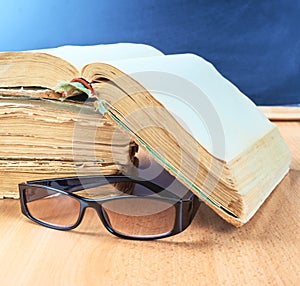 Glasses, old books and blackboard composition