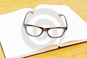 Glasses on open empty book