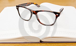 Glasses on open empty book