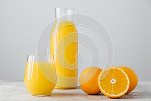 Glasses of orange juice, sliced fresh oranges on white background. Horizontal composition. Delicious fruit and drink. Citrus