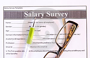 Glasses and pen on salary survey from