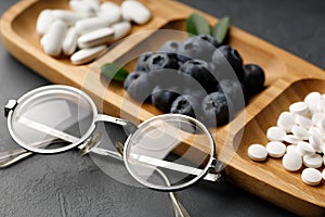 Glasses, pills and blueberries. The concept of replacing pills with berries.