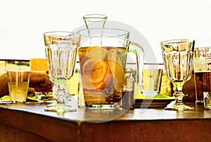 Glasses and pitcher with fruit lemonade orange, lemon, pear on table