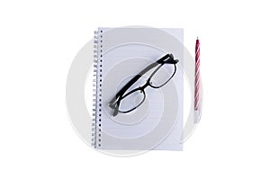 The glasses are placed on a notebook or book and a red pen is placed nearby.on isolated or white background