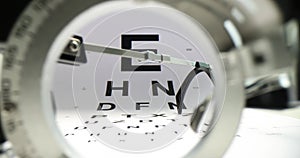 Glasses placed on paper Snellen chart to measure vision