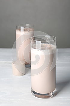 Glasses with protein shake and scoop of powder