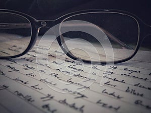 Glasses of reading on a book woth a bunch of sentences